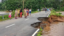 Villagers walk on a road that is partially damaged and washed away due to floods following heavy rainfall, in Goalpara district of Assam on Monday, May 25, 2020. 