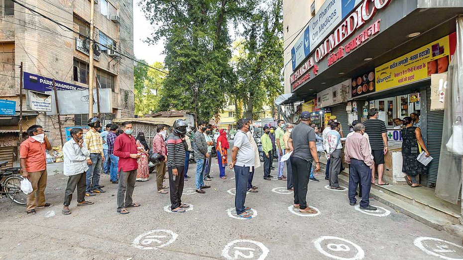 People observe social distance while waiting outside a chemist’s shop in Lucknow on Wednesday. 