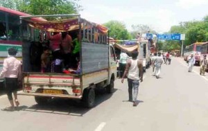 रोडवेज डिपो की बसों पर परीक्षण के बाद सवार होते मजदूर