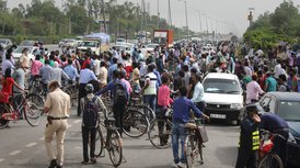 Police stop commuters, who were trying to cross the Delhi-Gurugram border, near Dhanchiri Camp in Gurugram, Friday, May 29, 2020.