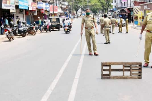 Policemen keep vigil on a road in Kerala's Kasargod during the lockdown. (News18) 