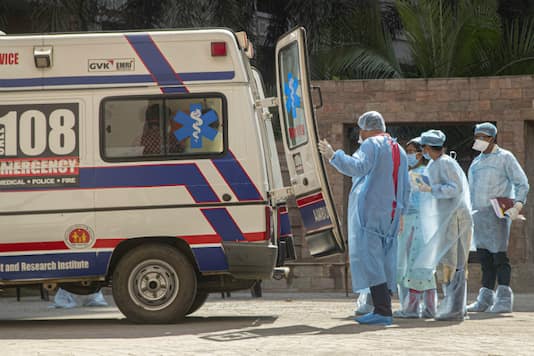 A health worker closes the door of an ambulance that will take people from an apartment complex to a hospital for quarantine after a contact was found to be COVID-19 positive, in Guwahati, on April 4, 2020. (AP Photo/Anupam Nath)