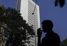 A man drinks tea as he walks past the Reserve Bank of India (RBI) headquarter building in Mumbai